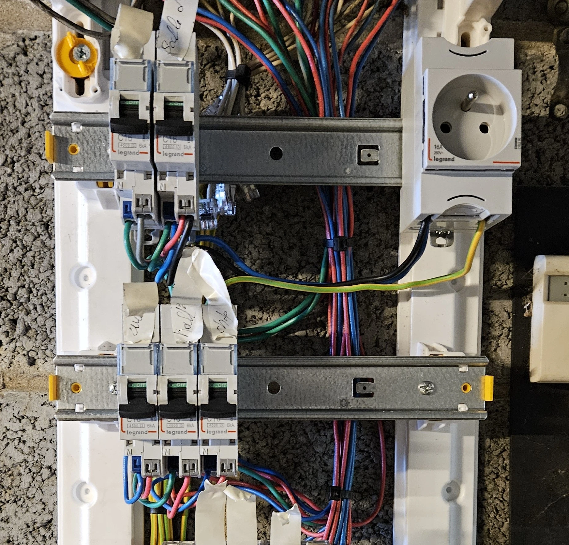 Tableau électrique ouvert avec disjoncteurs et câblage lors d’une intervention à Courrières